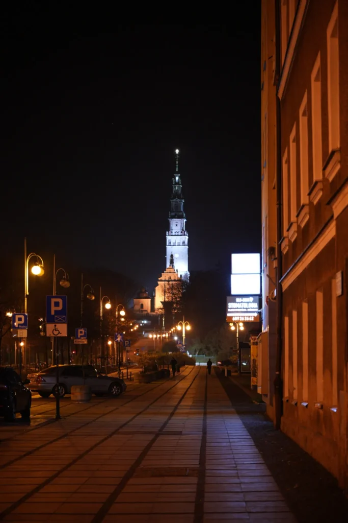 The illuminated tower of Jasna Gora seen along Saint Mary Avenue at night