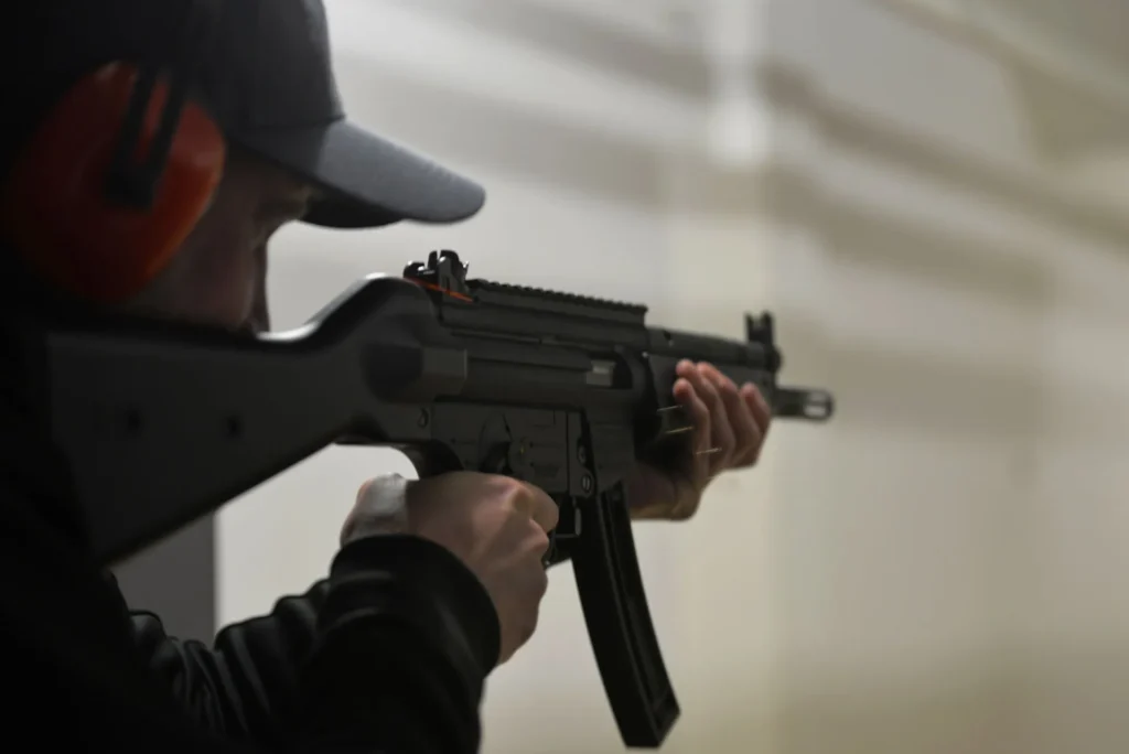 A person wearing hearing protection practising with a rifle at a shooting range