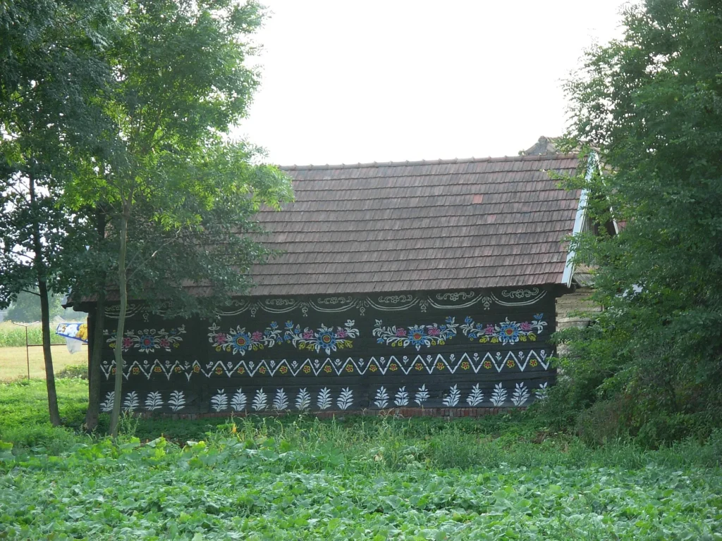 A wooden building with traditional floral wall decorations in Zalipie