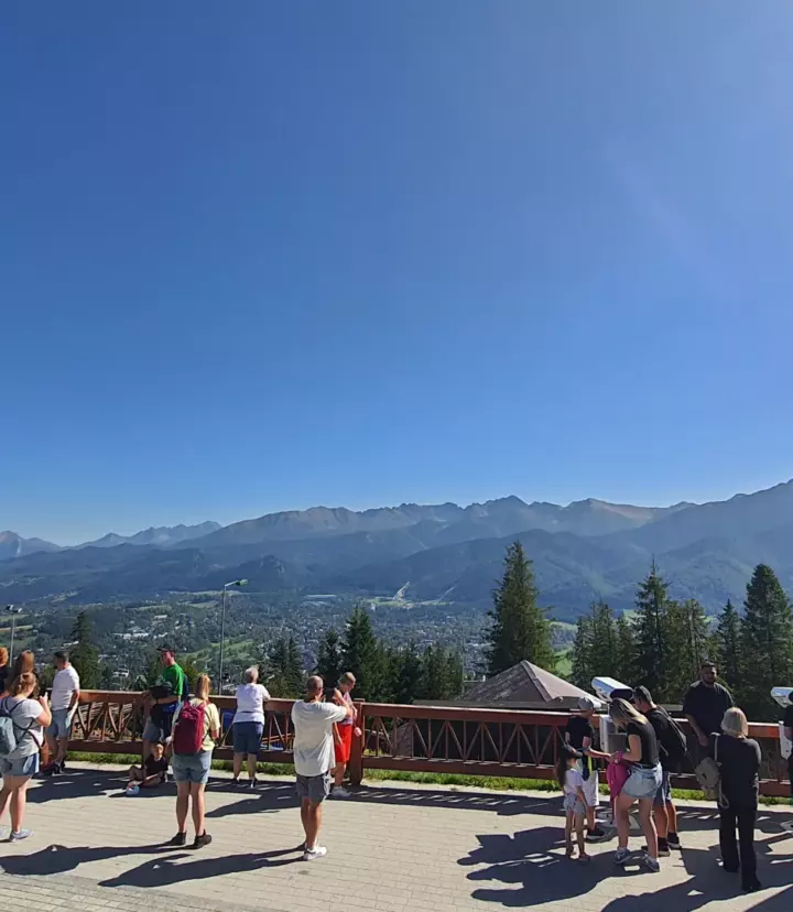 Visitors enjoying a panorama of the Tatra mountains from a Zakopane viewpoint