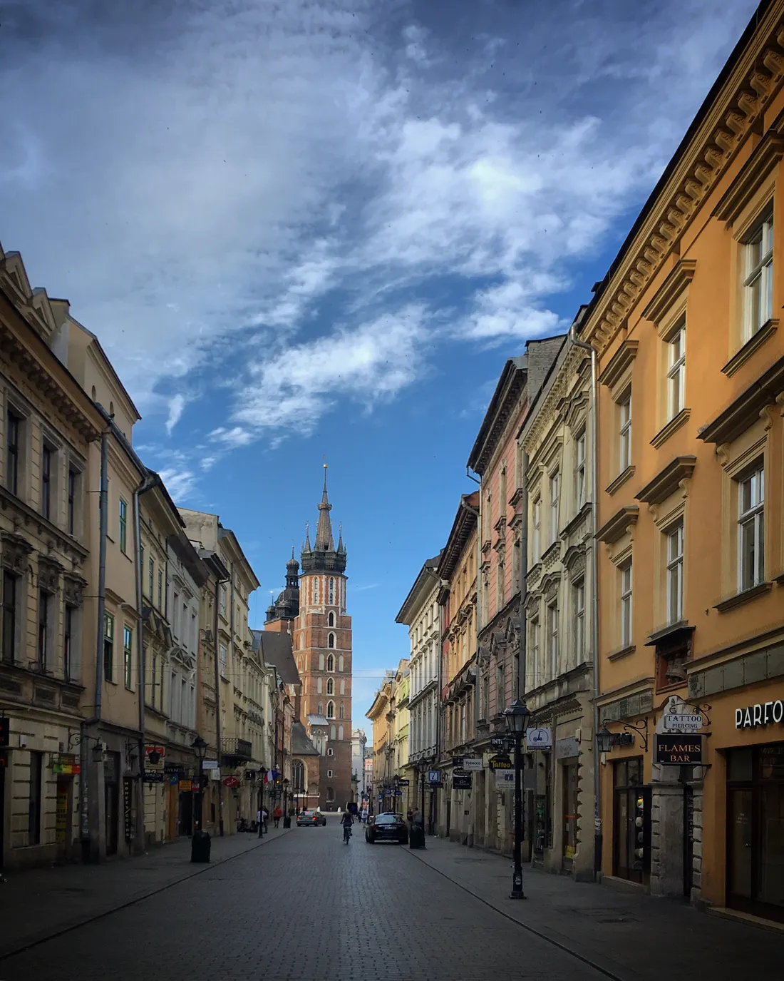Historic street in Krakow's Old Town leading towards St. Mary's Basilica