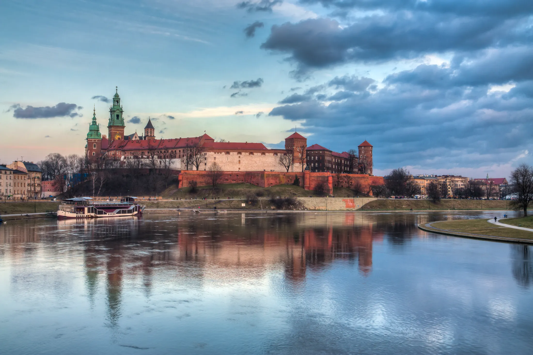 Wawel Castle reflected in the Vistula River at dusk in Krakow