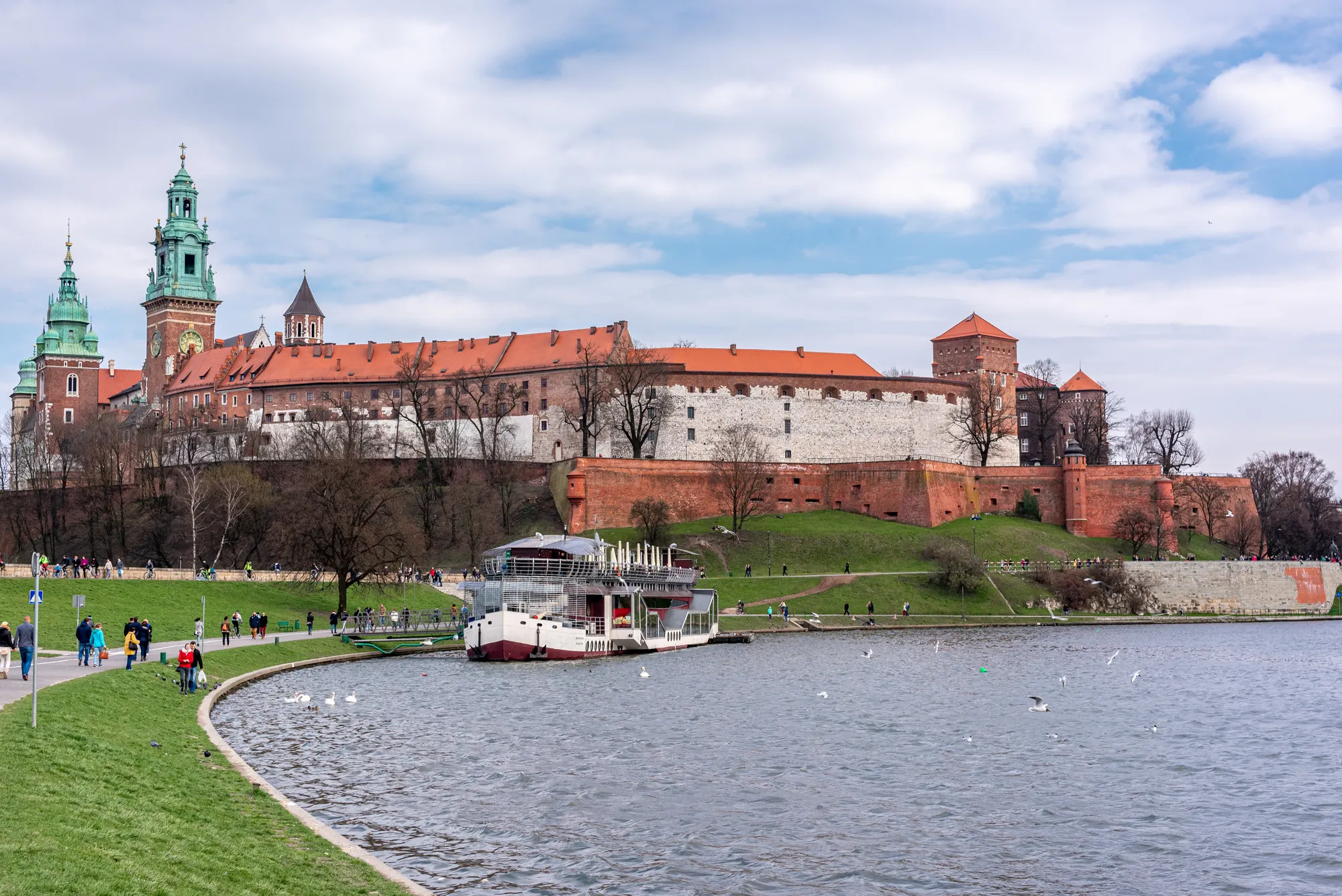 Wawel Castle above the green banks of the Vistula River in Krakow